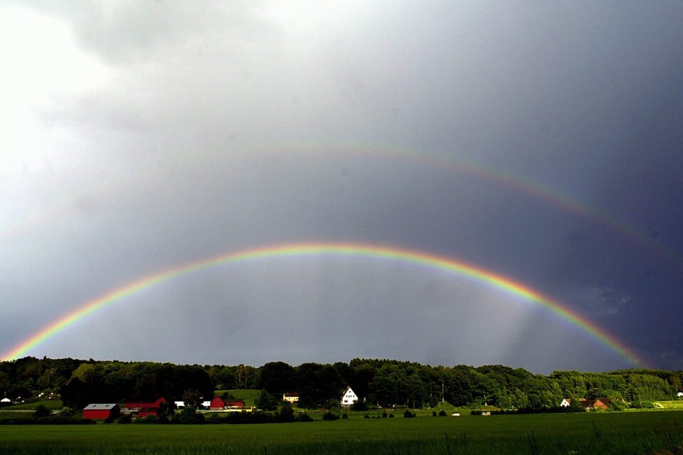 Dubbel regnbåge mot mörk himmel över Tormestorp. Foto: Ulrika Göthenqvist
