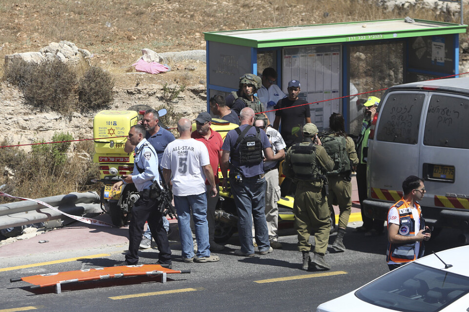 Israeliska soldater, poliser och sjukvårdspersonal vid platsen för bilattacken.