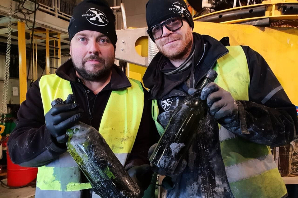 Dykaren Peter Lindberg (tv) och Floris Marsielle, specialist på undervattensteknik, med ett par av de 900 flaskor konjak och likör som nyligen bärgats från ett vrak i Ålands hav.