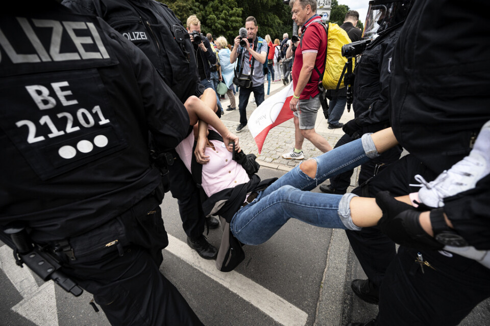 Polis griper en deltagare i den olagliga demonstrationen mot Tysklands coronaregler i Berlin på söndagen.