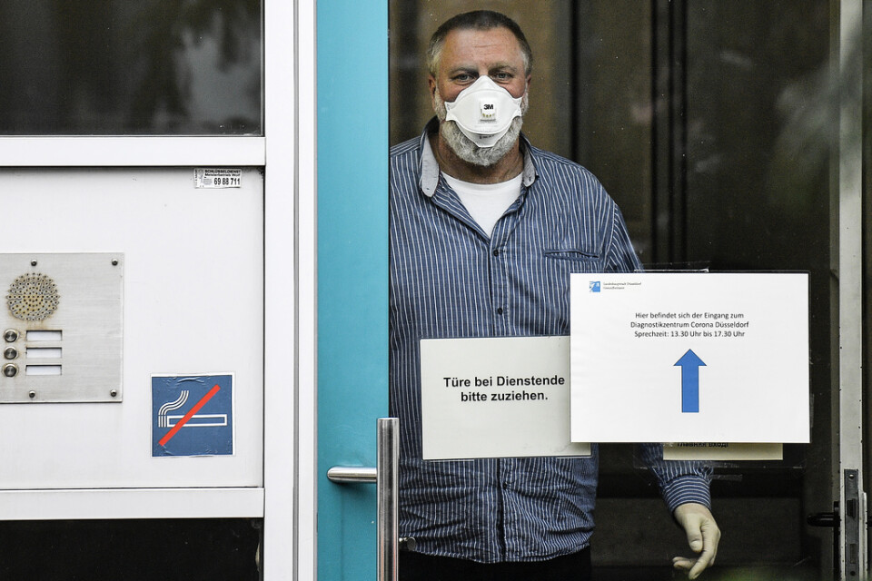 En anställd vid en vårdinrättning i Düsseldorf, Tyskland, har utrustat sig med munskydd och handskar.