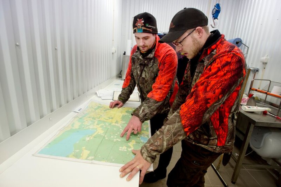 Petter Oskarsson och John Karlsson, två av tre jaktledare i Ströby älgjaktslag, går igenom vilka områden som är aktuella för dagens jakt.