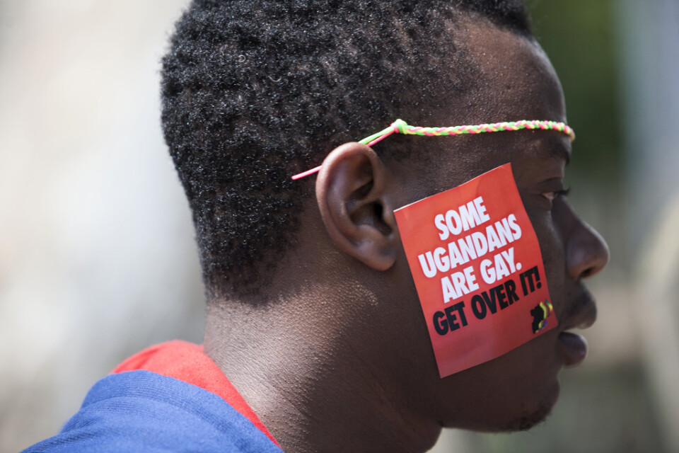 En man fångad på bild under en prideparad i Entebbe, Uganda, 2014. Då var samkönat sex förbjudet, men inte att tala om homosexualitet. På kinden har han ett märke där det står "Vissa ugandier är gay. Släpp det!".