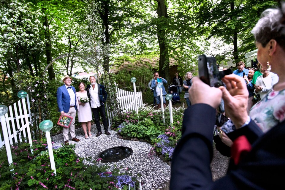 Flankerade av vårens blommande träd (och en mer tillfällig parkanläggning) lät sig de nygifta Mats Thunman och Marianne Dahlberg sig fotograferas med sin vigselförättare, författaren Björn Ranelid.