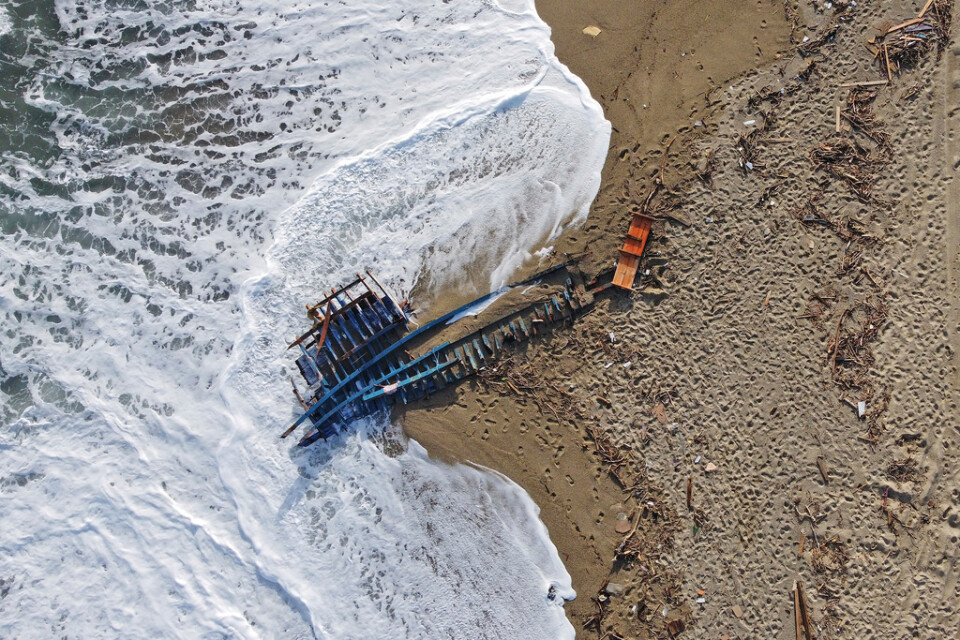 Båten slogs i spillror när den närmade sig den syditalienska kusten. Blått virke ligger uppspolat på stranden i regionen Kalabrien.