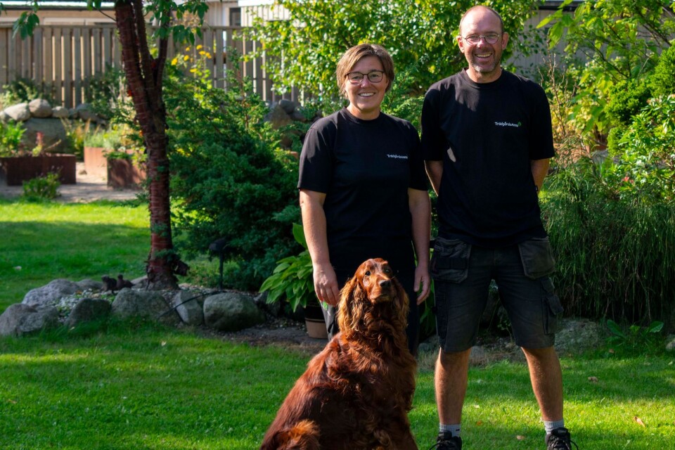 Anna Rickardsson Hellberg och Ted Hellberg med hunden Tristan i deras stora trädgård.