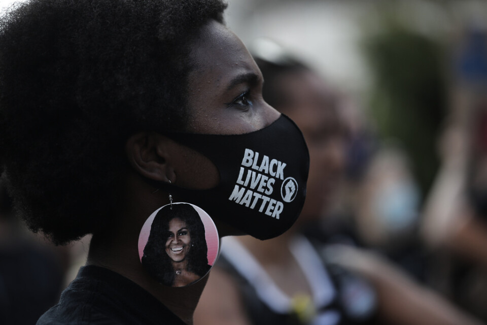 En kvinna i Michelle Obama-örhängen protesterar utanför Vita huset i Washington. Arkivbild.