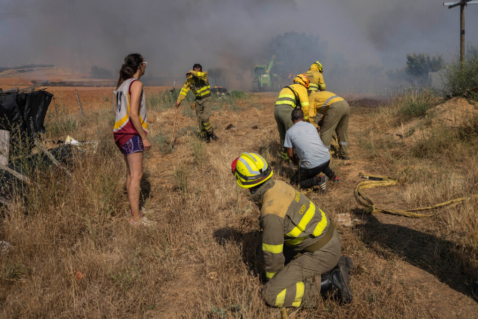 Brandkår i nordvästra Spanien i färd med att släcka en brand som letade sig närmare ett bostadshus. Bilden är tagen i juli i år.