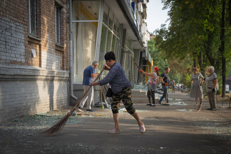 Invånare i Kiev städar bort glas och annan bråte efter en rysk drönarattack i slutet av augusti. Arkivbild.