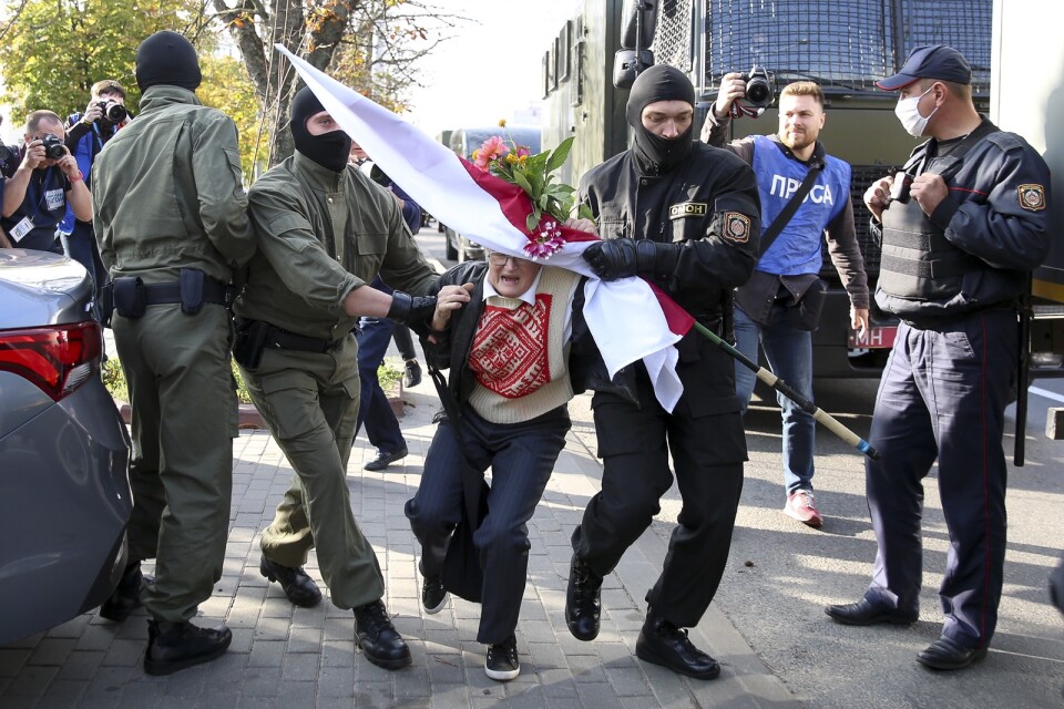 Nina Bahinskaja förs bort av poliser vid kvinnomarschen i Minsk i lördags.