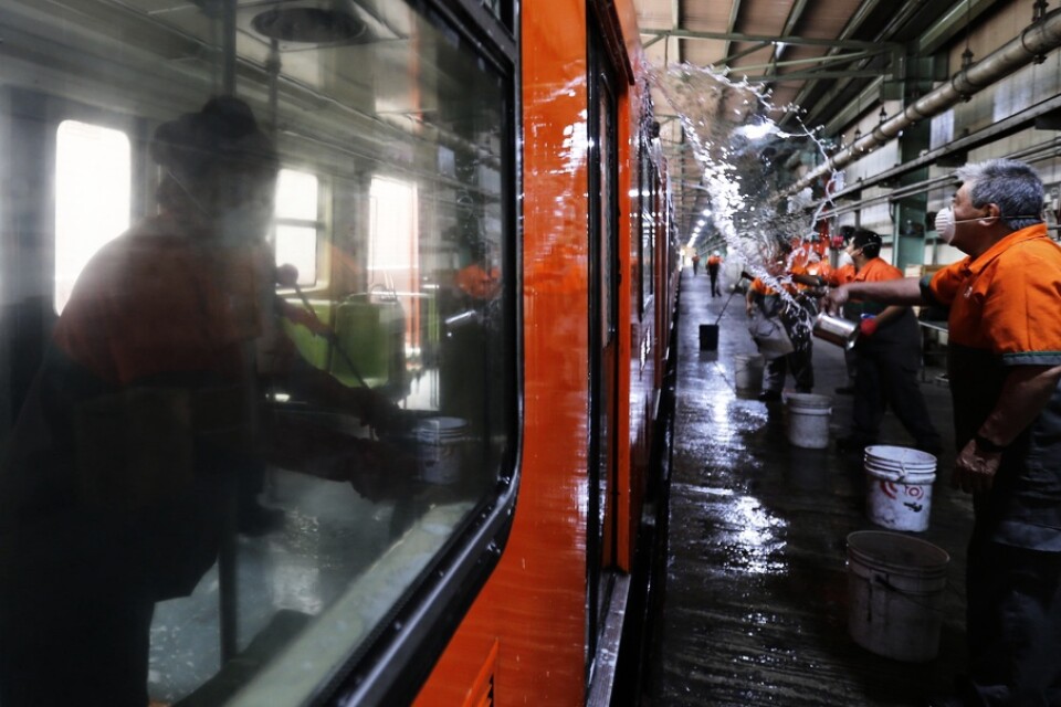 Renhållningsarbetare tvättar en tunnelbanevagn i Mexico City i syfte att motverka spridningen av det nya coronaviruset.