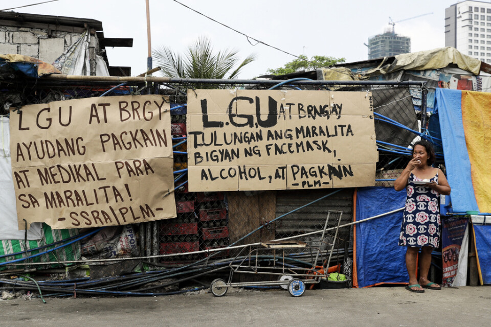 En handskriven skylt i ett slumområde i Manila vädjar om mat och medicinsk utrustning till den filippinska huvudstadens fattiga. Arkivbild.
