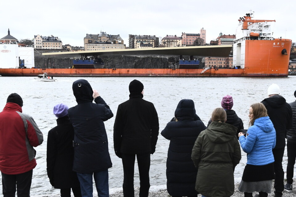Människor på kajen på Skeppsholmen tittar när lastfartyget Zhen Hua 33 anländer till Saltsjön och Slussen i Stockholm.