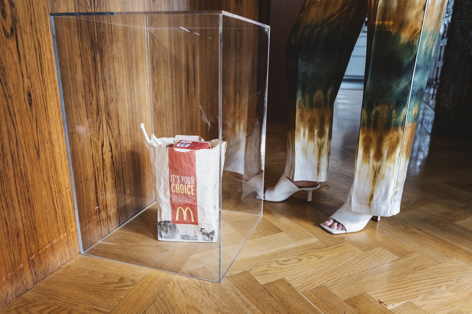 Malin och hennes man är konstintresserade. Det här verket av Peter Geschwind heter "Moving trash" och består av en McDonald's-påse med pappersförpackningar – samt en ljudaktiverad batteridriven leksak som gör att verket rör sig vid höga ljud.