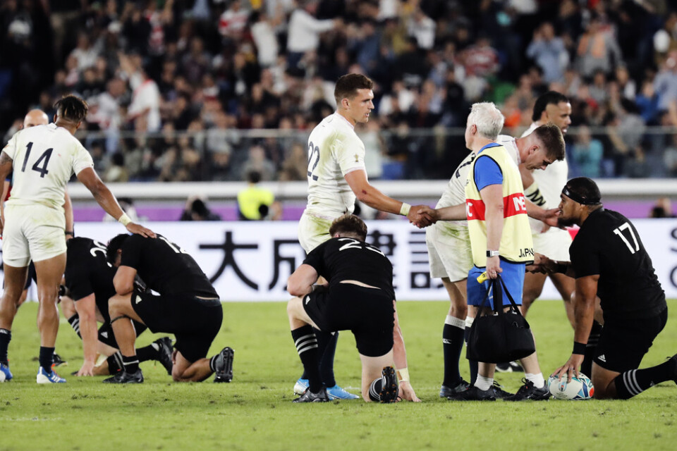 De nyzeeländska spelarna (i svart) var besvikna efter förlusten mot England.