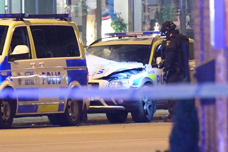 Poliser undersöker spår och skador på den polisbil som utsattes för ett sprängdåd på fredagskvällen. Foto: Johan Nilsson/TT