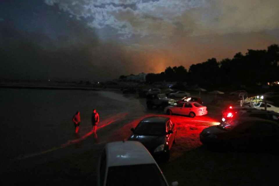 Människor samlade vid stranden i orten Mati, på flykt från de största bränderna på tio år.