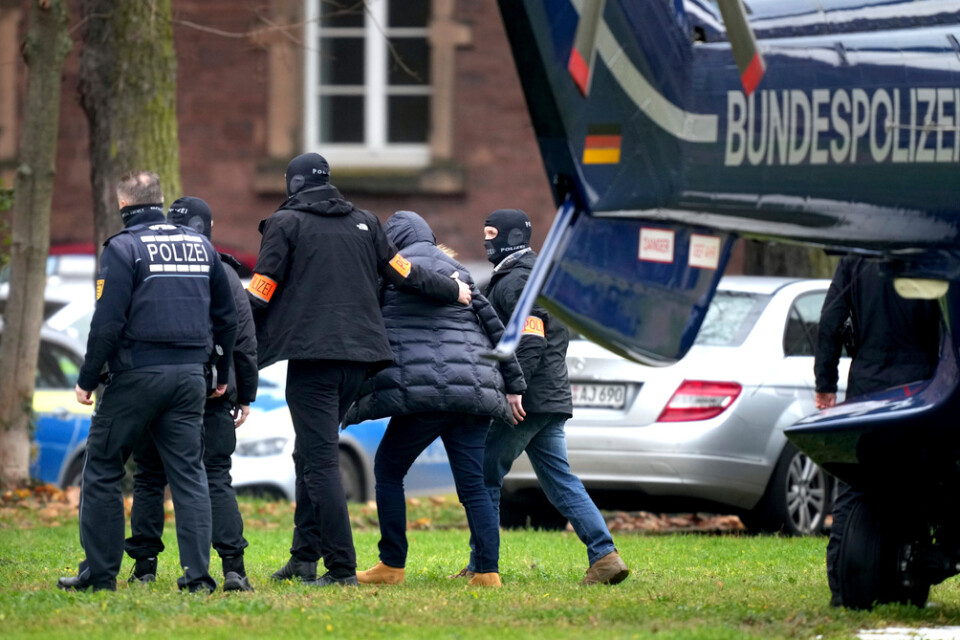 En misstänkt kuppmakare leds från en polishelikopter som har landat i Karlsruhe, efter de omfattande tillslagen på onsdagen.