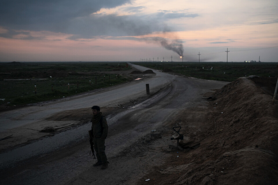 En milisman från kurdiska SDF på vakt nära ett oljefält i norra Syrien förra vintern. Kriget i Syrien kretsar delvis kring fossila bränslen, och IS tros de senaste åren ha dragit in mycket pengar på oljeförsäljning.