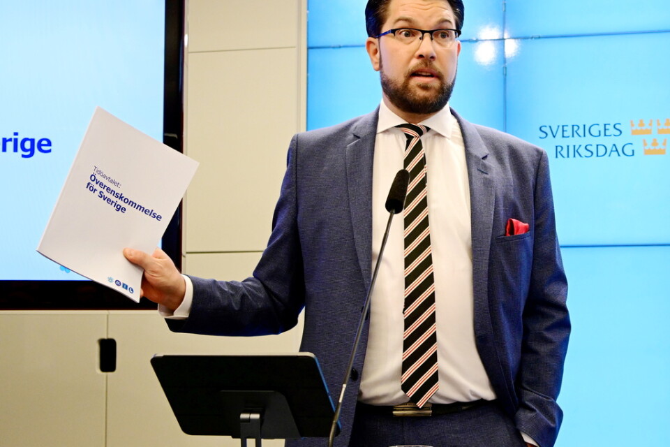 Sverigedemokraternas partiledare Jimmie Åkesson (SD) med överenskommelsen i handen vid gemensam pressträff, i riksdagens presscenter, om regeringsbildningen.