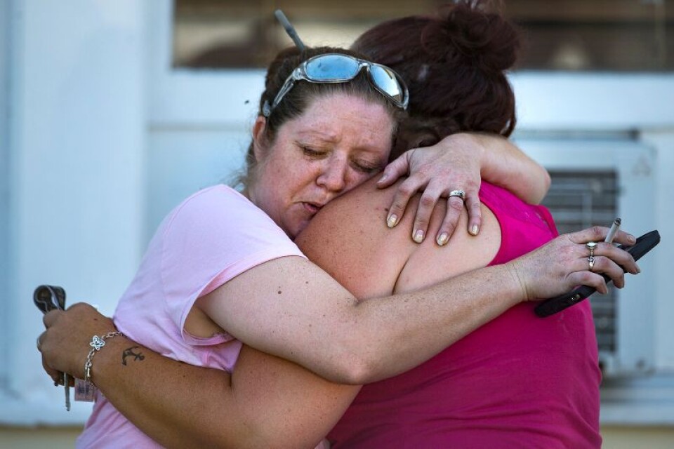 Två kvinnor omfamnar varandra efter den dödliga skjutningen i baptistkyrkan i Texasorten Sutherland Springs. Mer än 20 människor har dödats, enligt polisen.