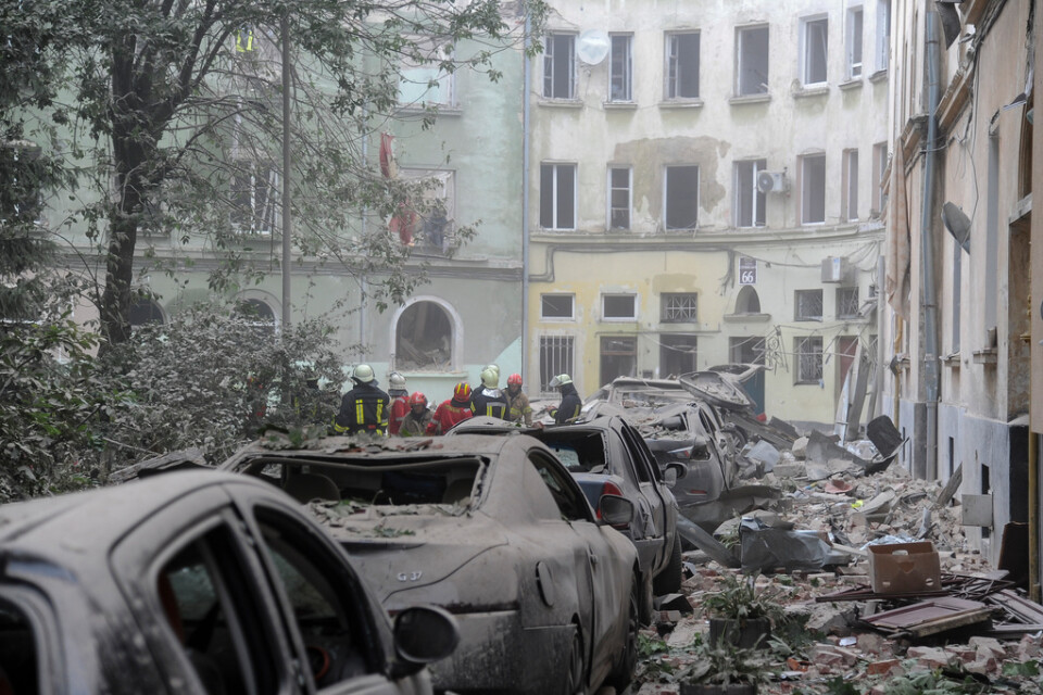 Bråte och havererade parkerade bilar kantar gatan utanför den sönderbombade byggnaden i Lviv.