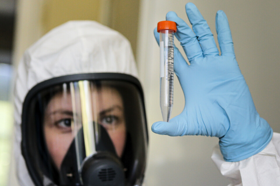 En anställd vid Gamaleja-institutet som utvecklat det nya ryska vaccinet visar upp det på en bild från den statliga ryska fonden RDIF, som finansierar vaccinet.