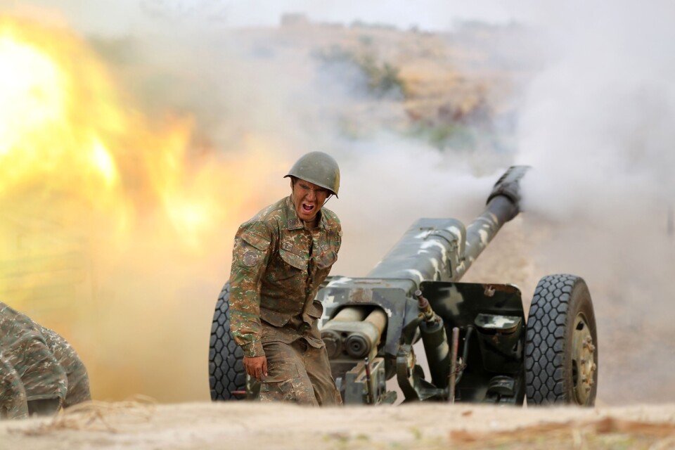 En armenisk soldat avfyrar artilleri mot azeriska posteringar nära den omtvistade utbrytarregionen Nagorno-Karabach.