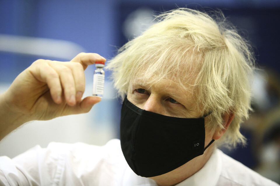 Storbritanniens premiärminister Boris Johnson visar upp en behållare med Astra Zenecas vaccin mot covid-19. Arkivbild.