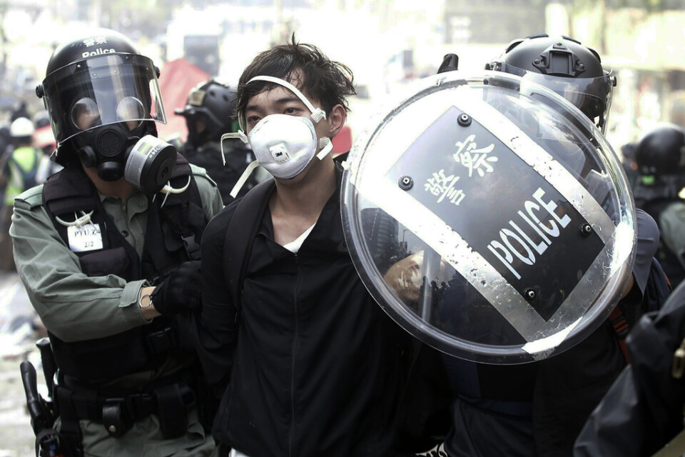 Polisen griper en demonstrant nära Hongkongs polytekniska universitet i Hongkong.