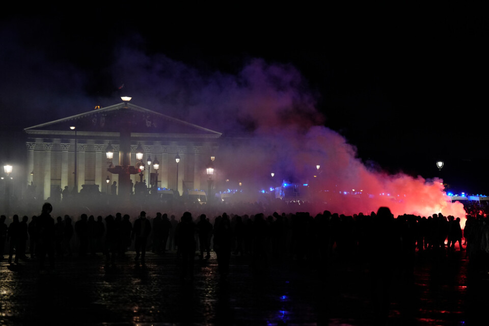 Demonstranter som under fredagskvällen samlats framför parlamentsbyggnaden i Paris.