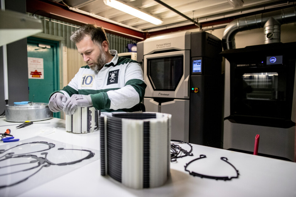 Niklas Hvit, tekniker i en 3D-printverkstad hos Volvo Cars, särar på hållare till visir från en industriell 3D-skrivare bakom honom. Här gick det snabbt att börja göra visir i en process med liknande tillverkning. Men att starta med något som kräver nya maskiner eller verktyg tar längre tid.