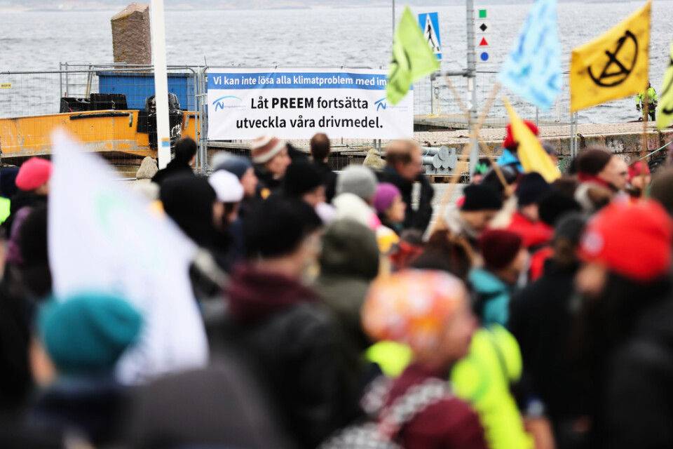Hundratals demonstranter hade kommit till Lysekil till den första förhandlingsdagen. I bakgrunden syns samtidigt en banderoll som är för en utbyggnad av raffinaderiet.