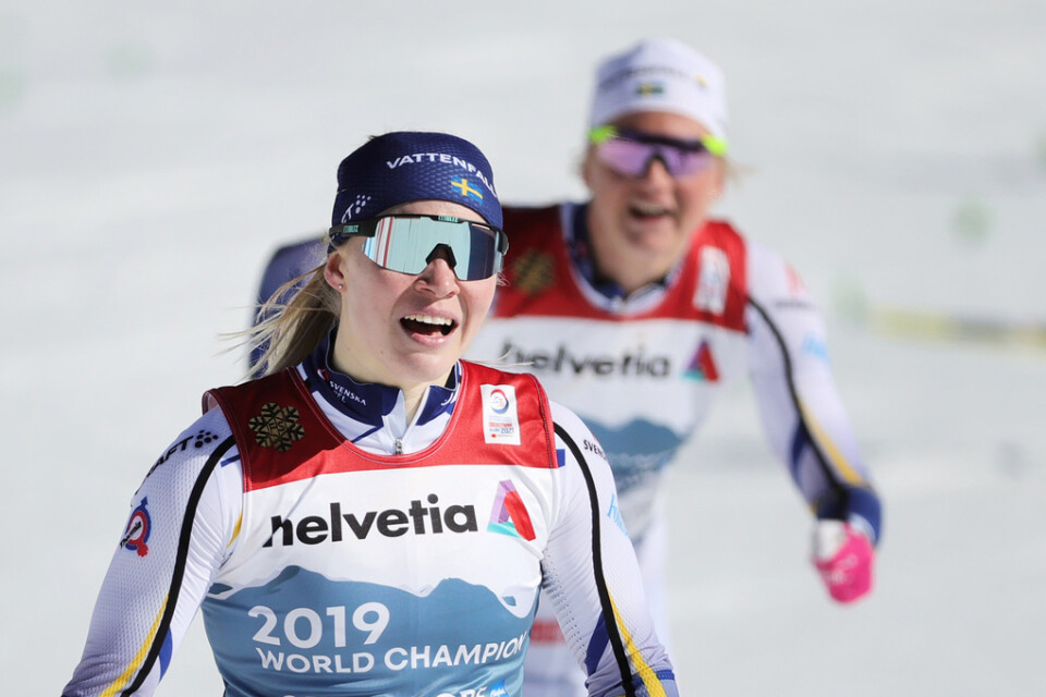 Jonna Sundling och Maja Dahlqvist (bakom) efter VM-guldet i sprintstafett förra vintern. Arkivbild.