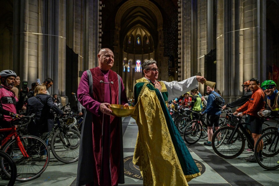 New York-cyklister mottar välsignelse och får en skvätt vigvatten på sig under cykelvälsignelseceremonin i Saint Johns-katedralen på Manhattan.