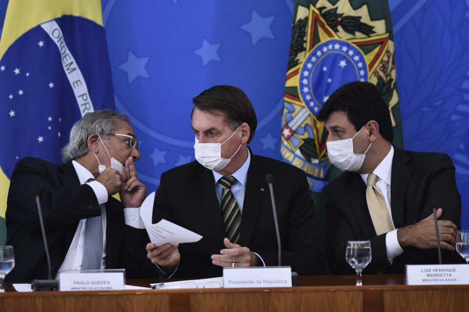 Brasiliens president Jair Bolsonaro och ministrar med munskydd. Bild från i mars.