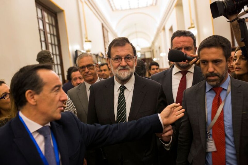 Spaniens premiärminister Mariano Rajoy, i mitten, får frågor av journalister när han lämnar det spanska parlamentet i Madrid under onsdagen.