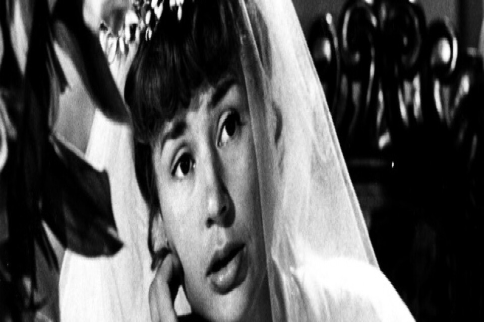 Skådespelaren Harriet Andersson klädd i brudklänning och brudslöja, i rollen som Agda i filmen "Älskande par" från 1964.