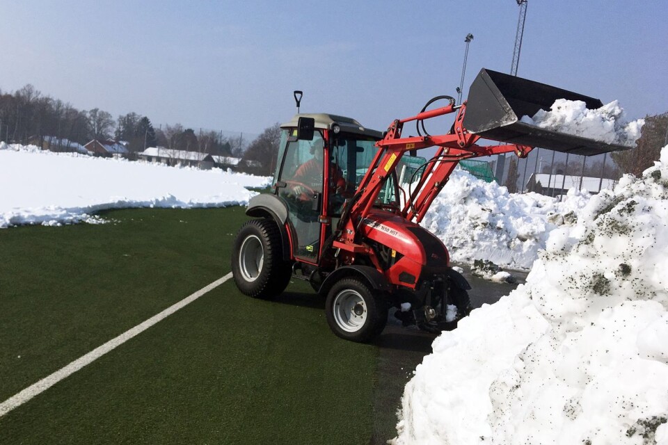 Vaktmästare Bertil Johansson i början av mars, när konstgräsplanen var täckt av snö. Traktorn på bilden gav upp, vilket slutade med att Kalmar kommun fick bidra med resurser för att få planen snöfri.