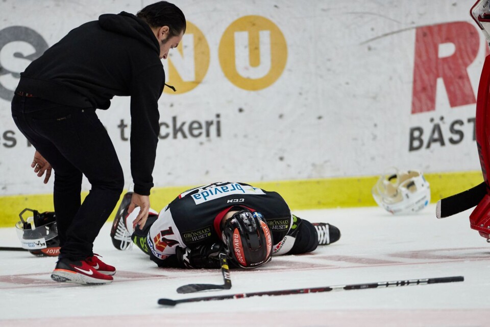 Redhawks Carl-Johan Lerby blir liggandes på isen efter tackling av Matt Carey under tisdagens match i SHL mellan IF Malmö Redhawks och Rögle BK i Malmö Arena.