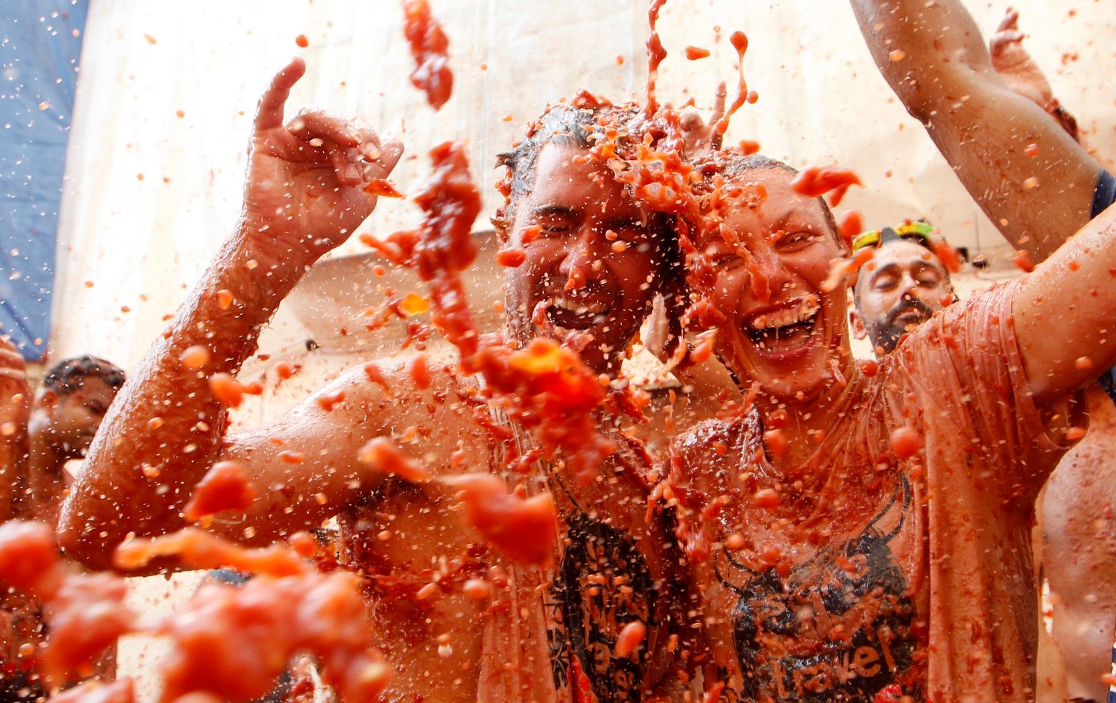 Revelers throw tomatoes during the annual "Tomatina", tomato fight fiesta, in the village of Bunol, 50 kilometers outside Valencia, Spain, Wednesday, Aug. 29, 2018. At the annual "Tomatina" battle, that has become a major tourist attraction, trucks dumped 160 tons of tomatoes for some 20,000 participants, many from abroad, to throw during the hour-long Wednesday morning festivities. (AP Photo/Alberto Saiz)