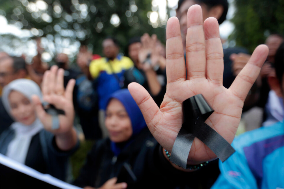 Kvinnor bär svarta rosetter som sorgesymbol för de 125 människor som förolyckades i samband med läktartragedin i Indonesien.