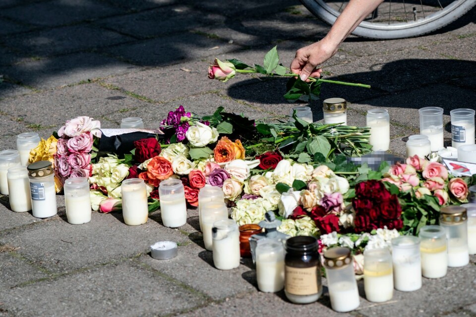 En kvinna lägger ner en ros vid minnesplatsen på Sergels väg i stadsdelen Ribersborg i Malmö där en 30-årig kvinna sköts till döds i måndags, 26 augusti.