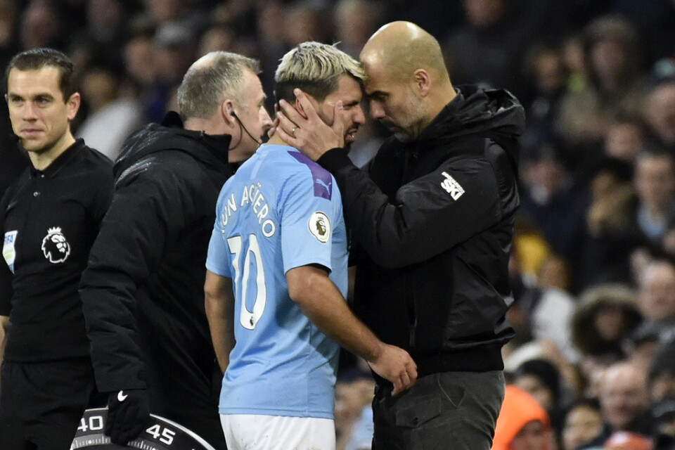Manchester Citys tränare Pep Guardiola pratar med Sergio Agüero som lämnar planen skadad.
