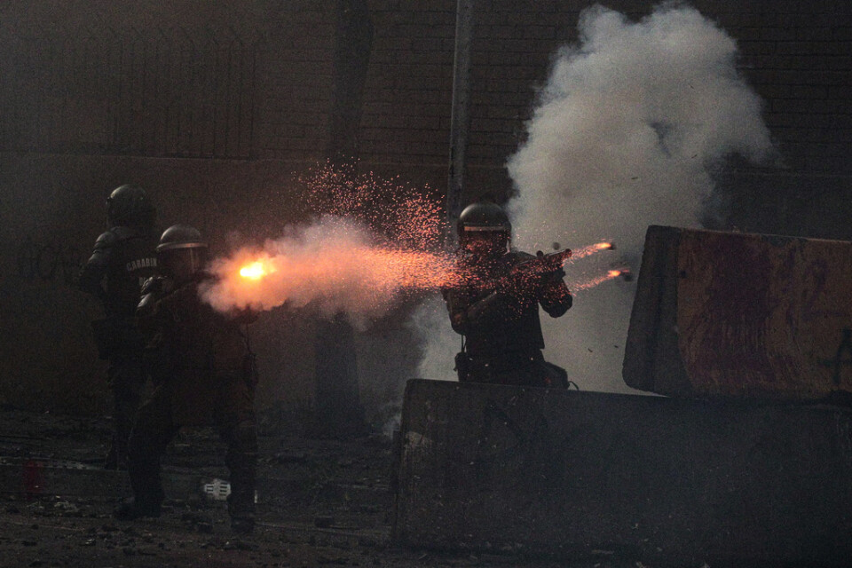 Poliser avfyrar tårgasbehållare mot demonstranter under protester i Chiles huvudstad Santiago den 6 mars. Arkivbild.