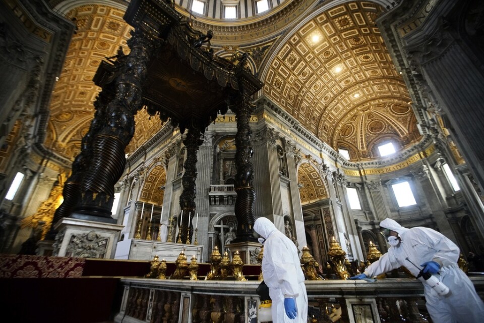 Arbetare i skyddsdräkter sanerar Peterskyrkan i Rom inför öppnandet på måndag.