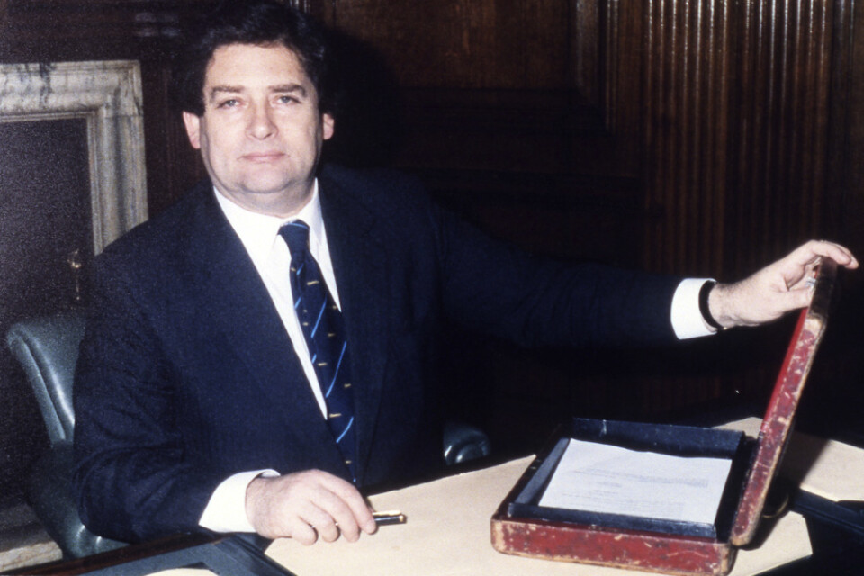 Nigel Lawson och "budgetlådan". Den användes vid den brittiska motsvarigheten till Sveriges budgetpromenad, då finansministern tar sitt budgetförslag till parlamentet. Bilden är från våren 1987.