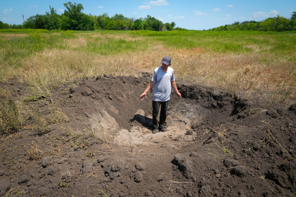 Bördig jord, men förstörd av kriget. En bonde i östra Donetsk visar en krater i hans åker som orsakats av en rysk projektil. Bilden tagen i juni i år.