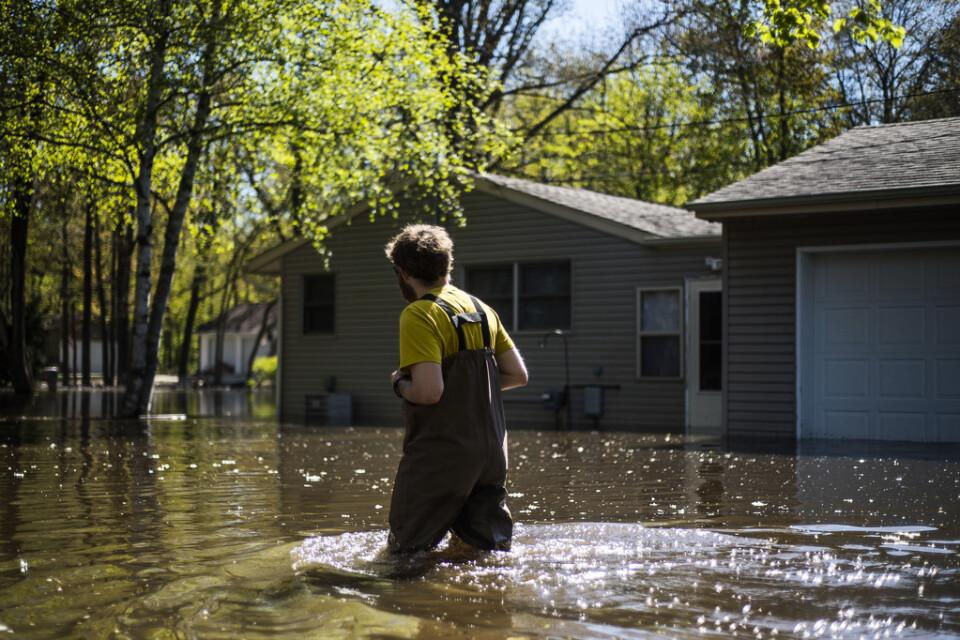 En boende i Midland, Michigan, vadar genom vattenmassorna för att nå sitt hem.