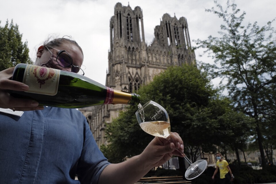 Ett glas champagne serveras i Reims i Frankrike – men marknaden ser mörk ut för vinproducenterna.
